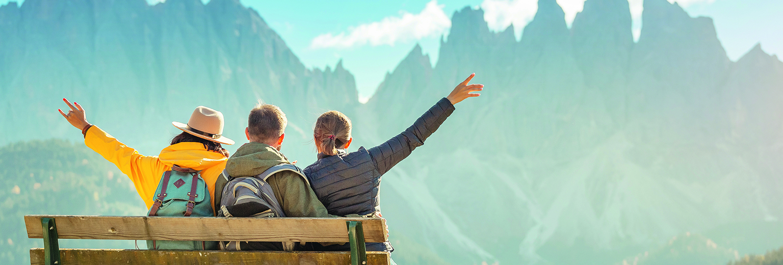 Active three friends travel during autumn holiday and vacation in the mountains of the Dolomites in the Bolzano region in Italy