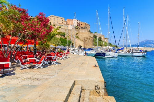 Ansicht des Restaurants und der Zitadelle mit Häusern im Hafen von Calvi,Korsika,Frankreich