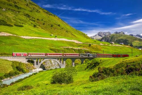 Die Matterhorn - Gotthard - Bahn auf der Viaduktbrücke bei Andermatt in den Schweizer Alpen