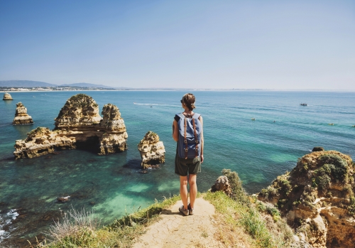 Weiblicher Reisender, der das Meer in Lagos-Stadt betrachtet,Algarve-Region,Portugal. Reise- und aktives Lebensstilkonzept