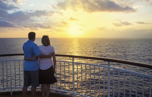 Couple on a cruise watching the sunset over the ocean