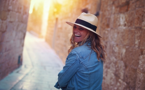 Young stylish woman laughing on mediterranean street