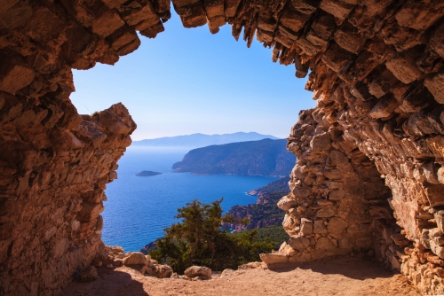 Sea skyview landscape photo from ruins of Monolithos castle on Rhodes island, Dodecanese, Greece. Panorama with green mountains and clear blue water. Famous tourist destination in South Europe