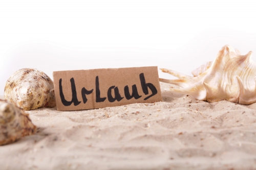 Schild Urlaub, Muscheln und Sand