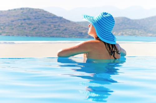 Woman in hat relaxing at swimming pool