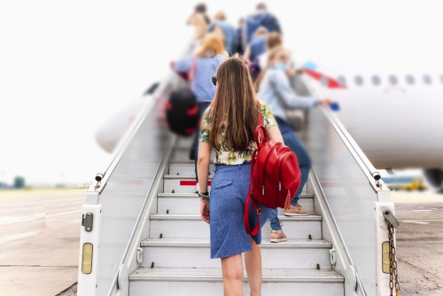 junge Frau auf der Treppe des Flugzeugs in den Urlaub