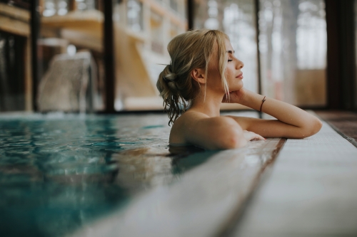 junge Frau, die sich im Spa-Schwimmbad entspannt