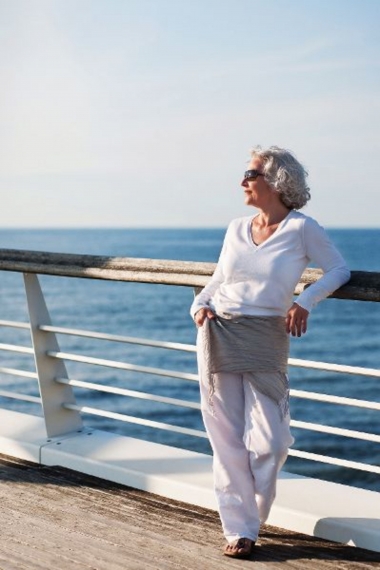 attraktive Seniorin genießt die Kreuzfahrt auf dem Sonnendeck