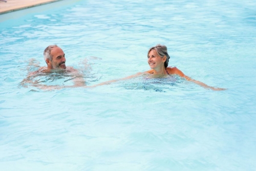 Active senior couple in resort pool