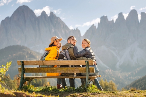 drei aktive Freunde genießen ihre Reise während der Herbstzeit in den Bergen der Dolomiten