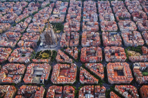 Luftaufnahme von Barcelonas schachbrettartig angelegtem Stadtviertel Eixample und der Kathedrale Sagrada Familia