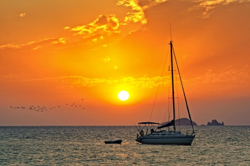 Segelboot im Sonnenuntergang vor der Küste von Ibiza