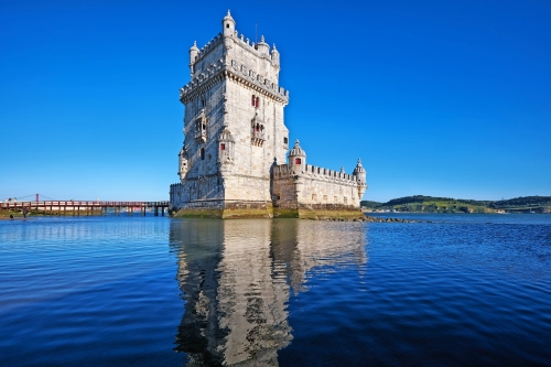 Belem-Turm am Fluss Tejo in Lissabon mit Reflexion in Wasser auf blauem Himmel Hintergrund, Portugal