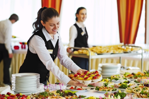 Restaurant Kellnerin serviert Tisch mit Essen
