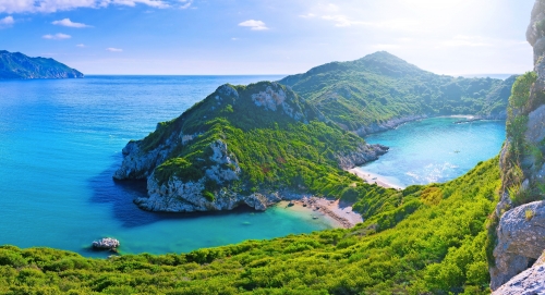 Panoramischer Meerblick der schönen Sommerzeit. Blick auf die Klippe in die kristallklare azurblaue Meeresbucht und die fernen Inseln. Einzigartiger abgeschiedener Strand. Agios Stefanos Umhang. Afionas. Korfu. Griechenland.