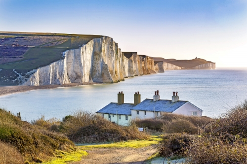 Die Küstenwache-Häuschen und sieben Schwester-Kreide-Klippen gerade außerhalb Eastbourne, Sussex, England, Großbritannien.