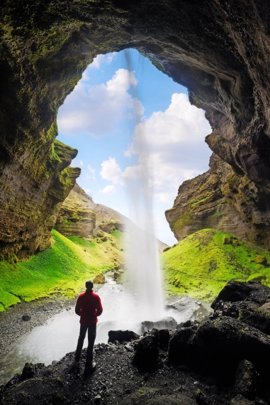 Tourist betrachtet den großen Wasserfall in Island